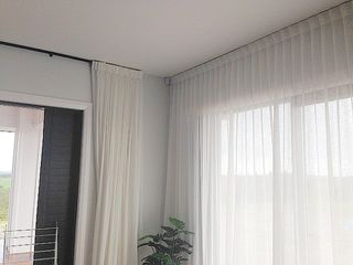 White sheer curtains on black track